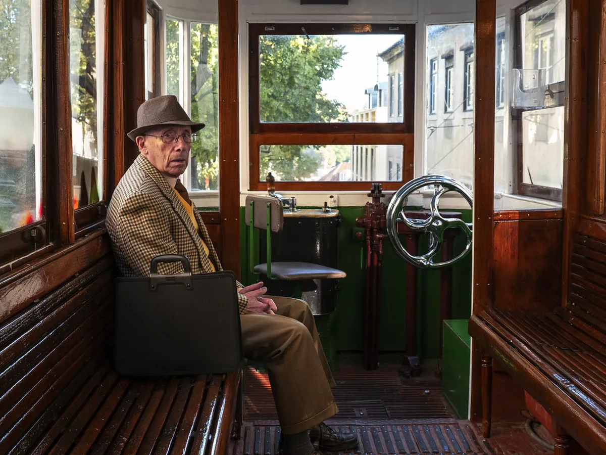 Crowded interior of a Lisbon vintage tram with standing passengers close together near the windows