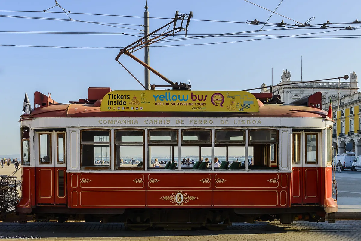 Families boarding a Lisbon tram, showing the narrow entrance and steps that make travelling with children a challenge