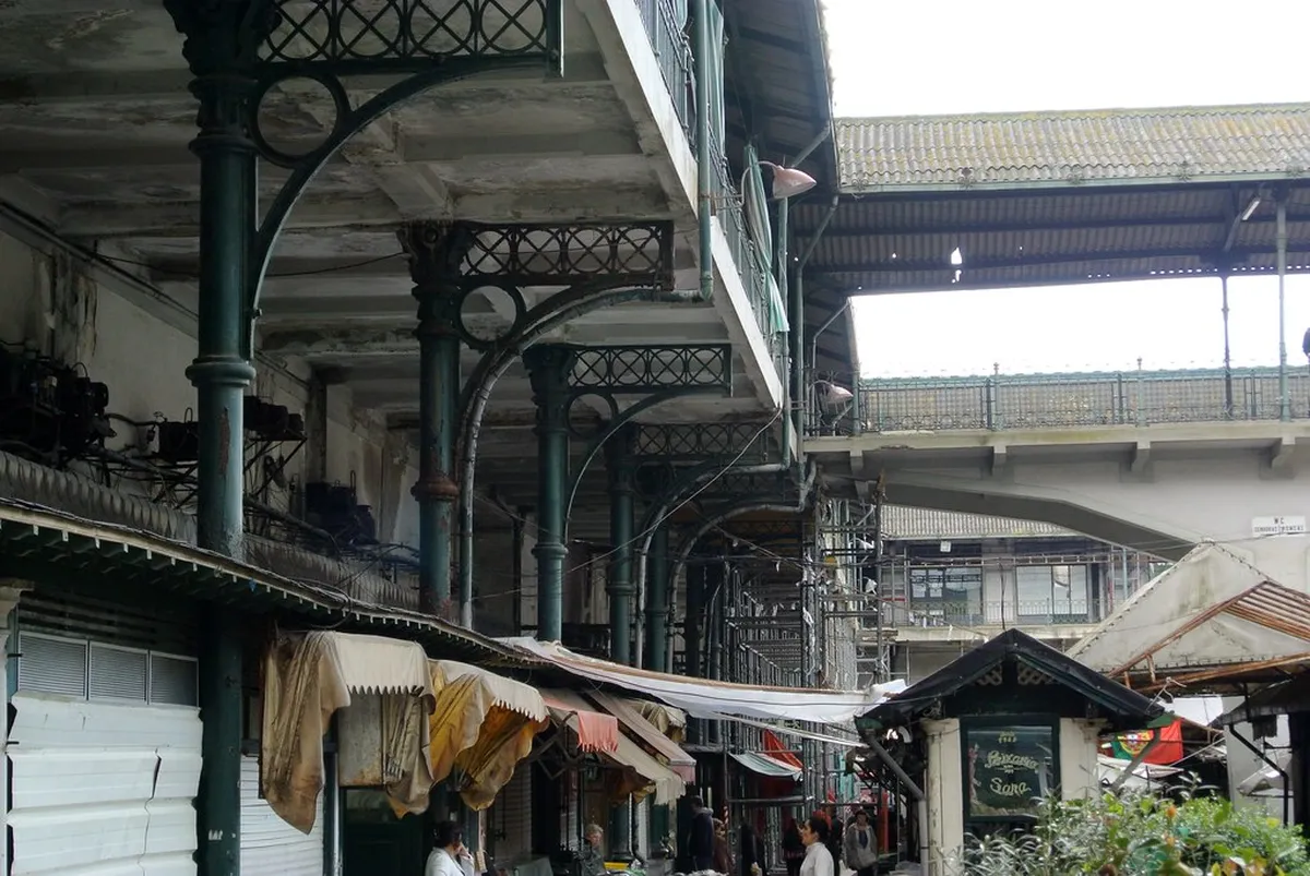 Porto Mercado do Bolhão interior with vendors selling fresh produce and flowers under iron-and-tile arcades