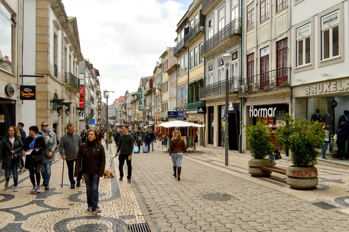 Pedestrians strolling along Rua de Santa Catarina, Porto's iconic shopping street lined with colourful facades
