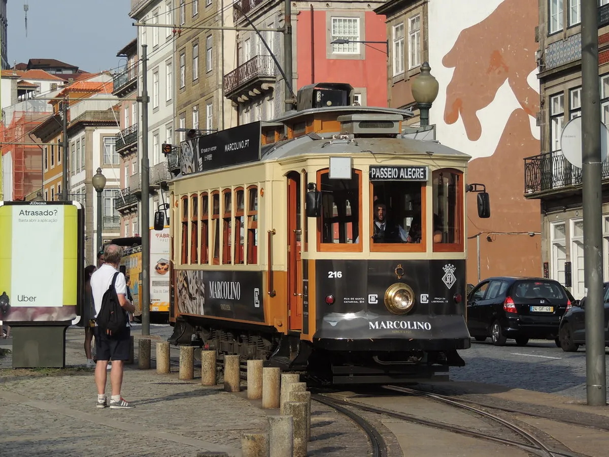 Porto vintage tram travelling through historic cobblestone streets on a scenic route through the city