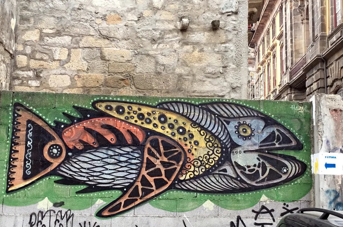 Colourful large-scale street art mural painted on a building wall in Porto's Cedofeita art district