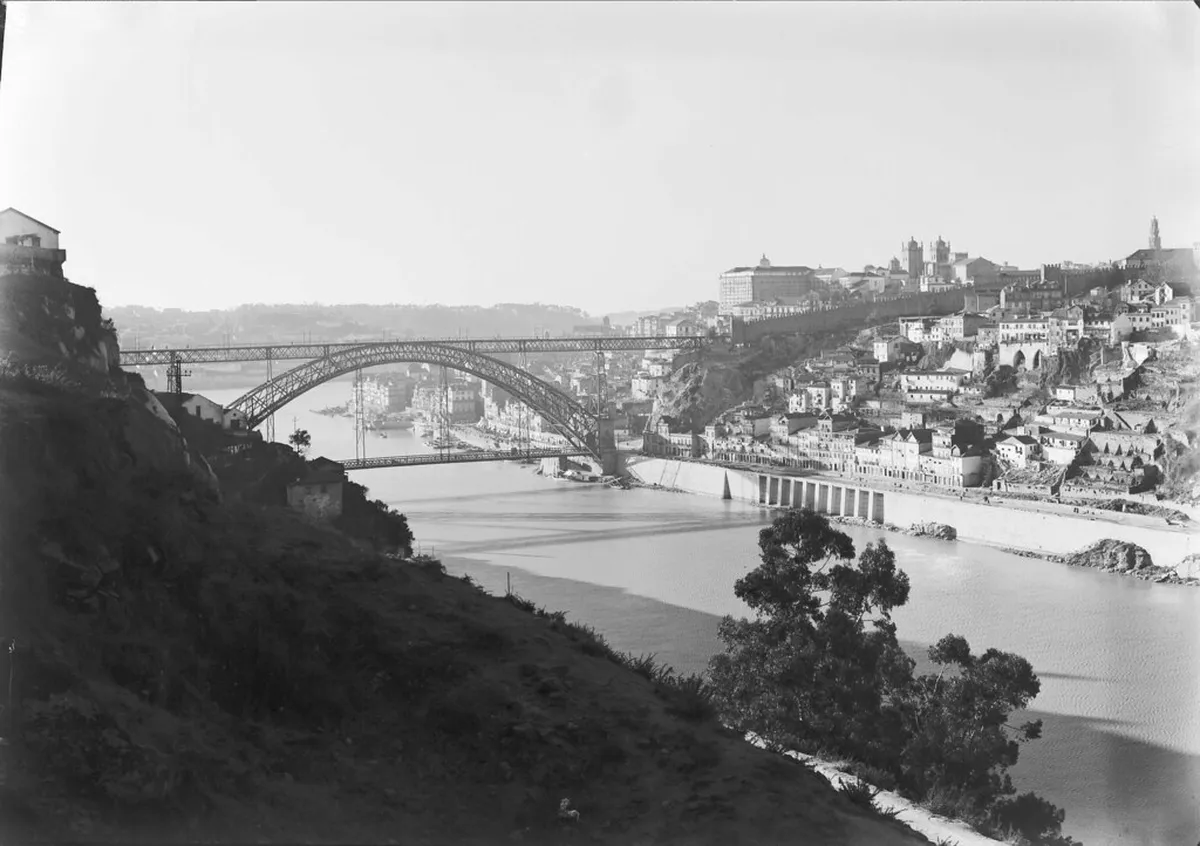 The iconic Dom Luís I Bridge spanning the Douro River in Porto, with colourful buildings of the Ribeira district below