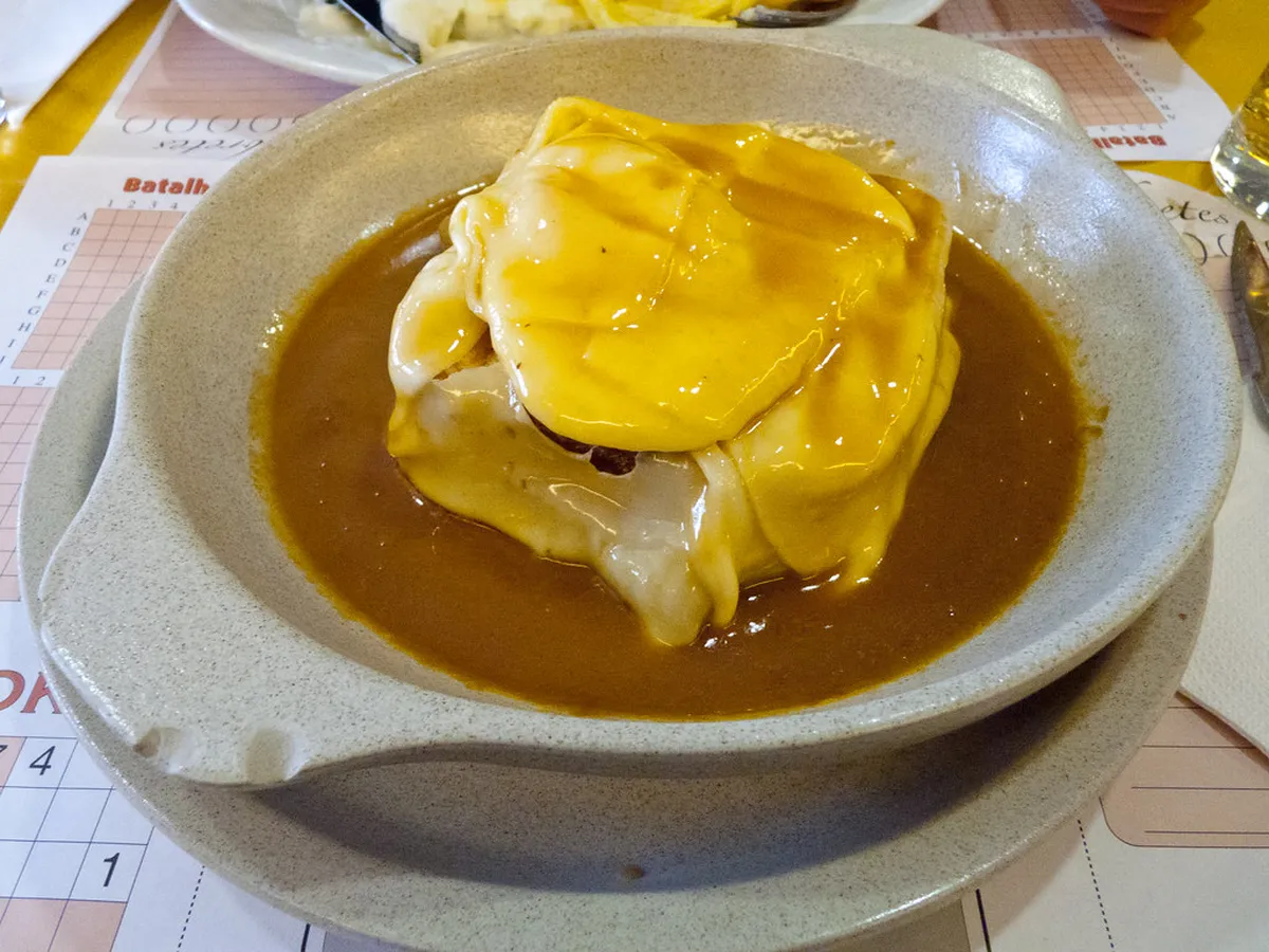 A traditional Porto Francesinha sandwich served at a classic tasca in Baixa, Porto