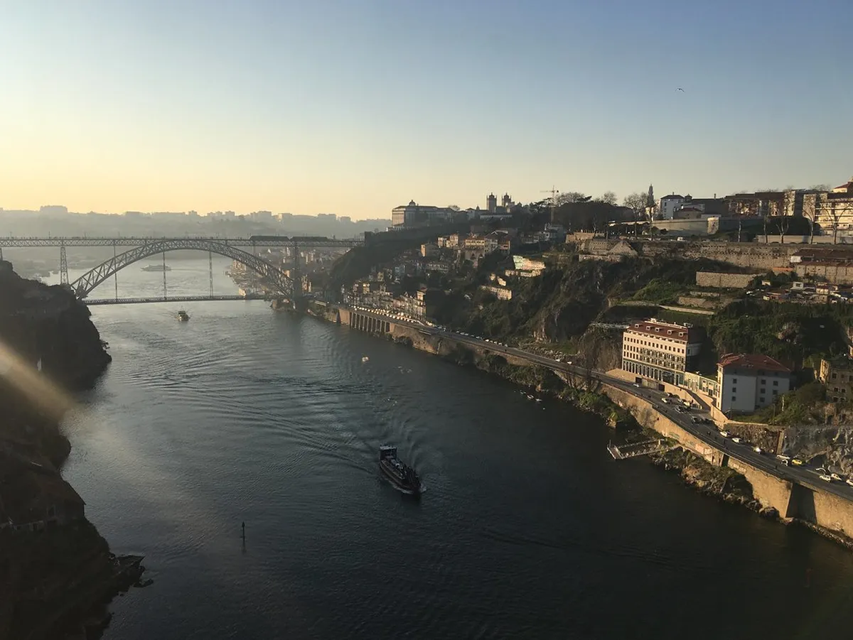Traditional Rabelo boats moored along the Porto waterfront with the Douro River and city hillside in view