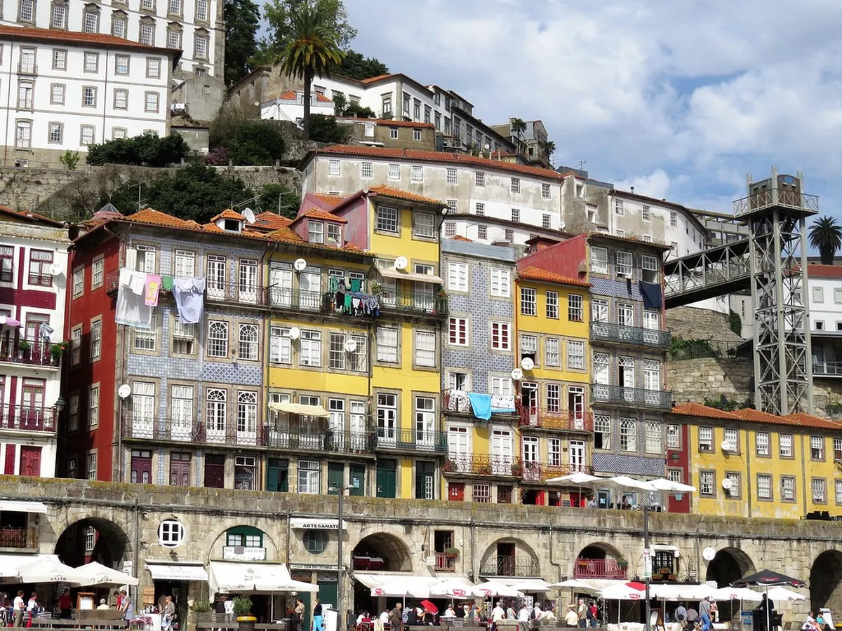 Colorful facades and café terraces lining the Porto Ribeira waterfront along the Douro River