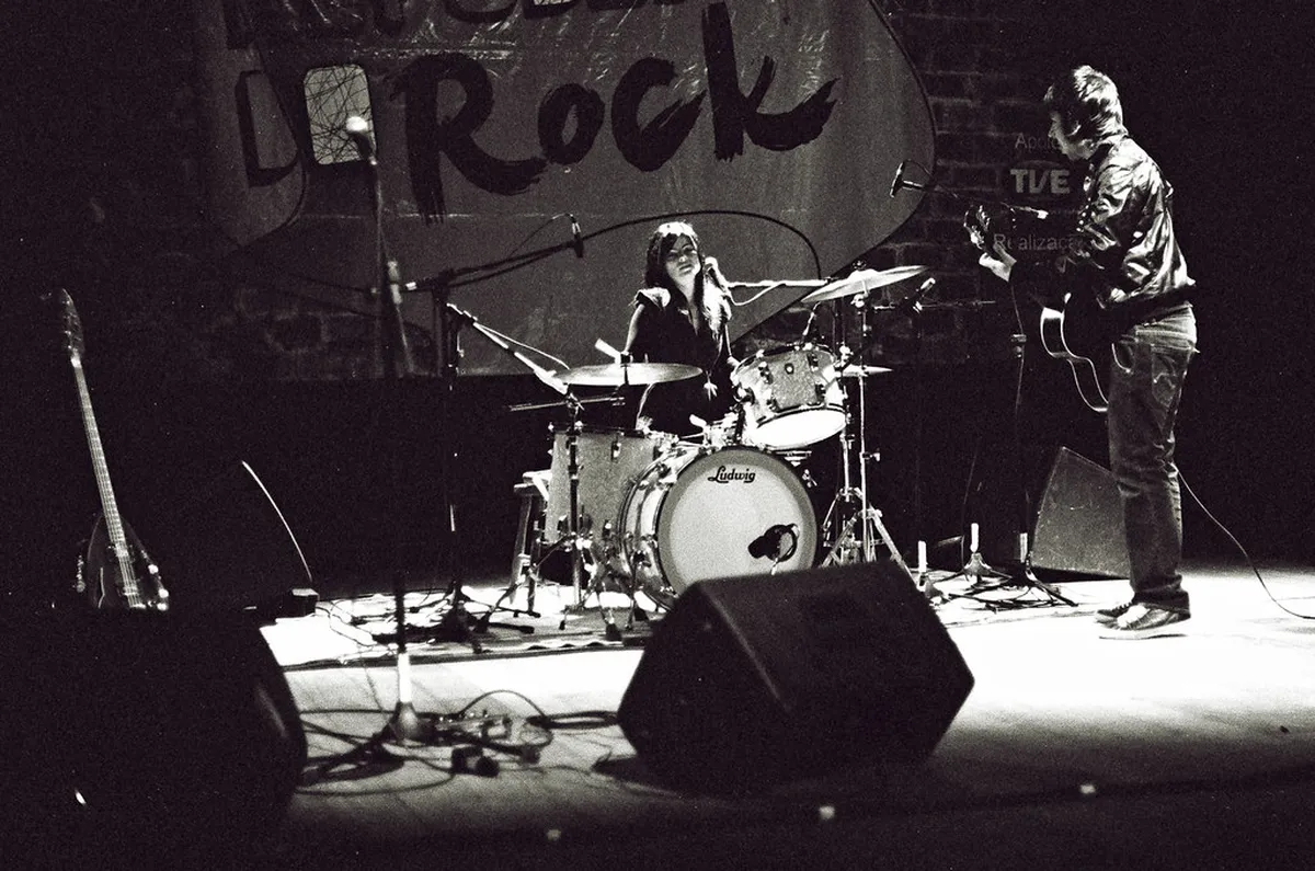 Live indie music performance at a Porto venue, with band members on stage entertaining a young local audience