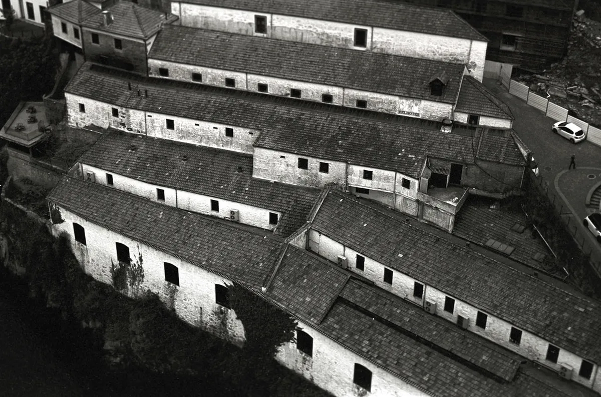 Rows of aged Port wine barrels inside a dimly lit cellar during a tasting tour in Porto
