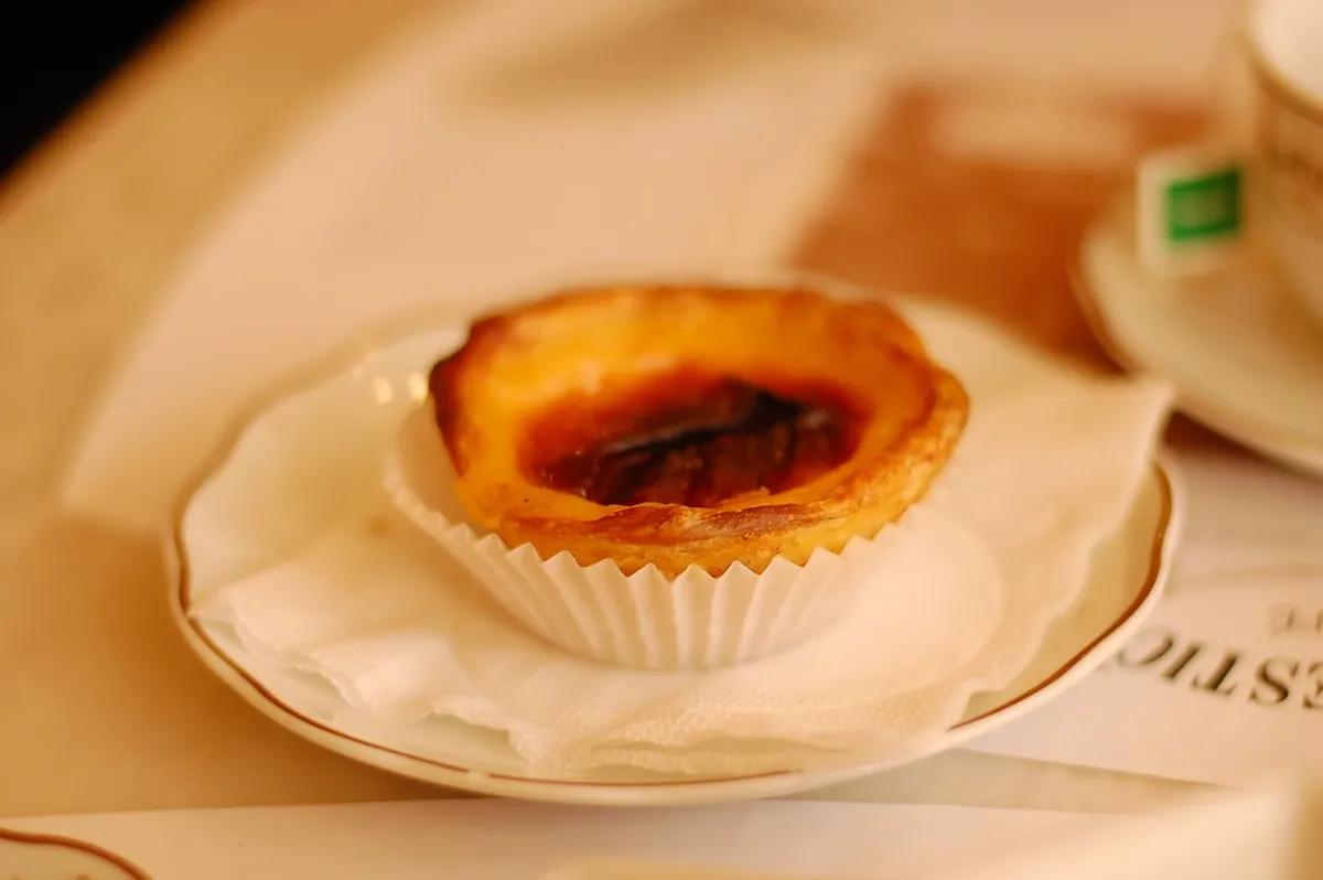 Traditional Portuguese pastel de nata custard tarts served in a Porto cafe alongside espresso coffee