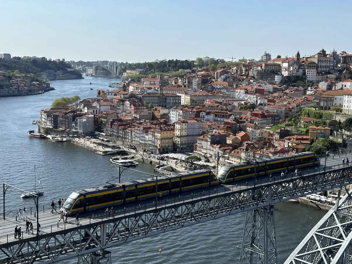 Porto historic tram navigating narrow cobbled streets in the Ribeira waterfront district