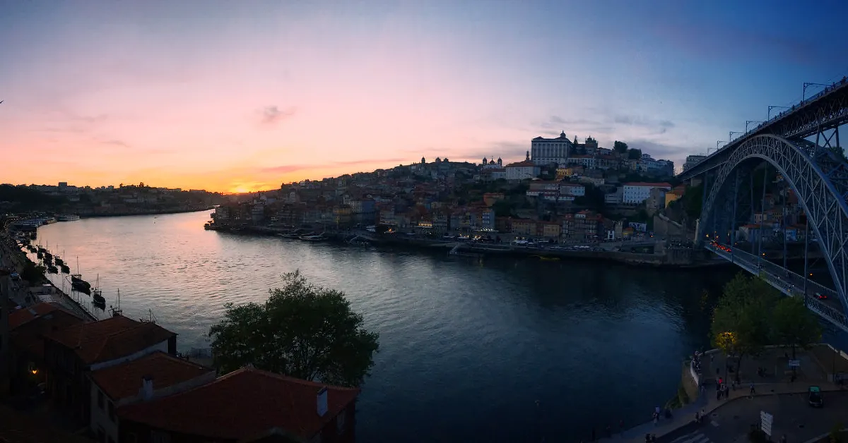 Porto Ribeira district at night with illuminated historic buildings reflecting on the Douro River