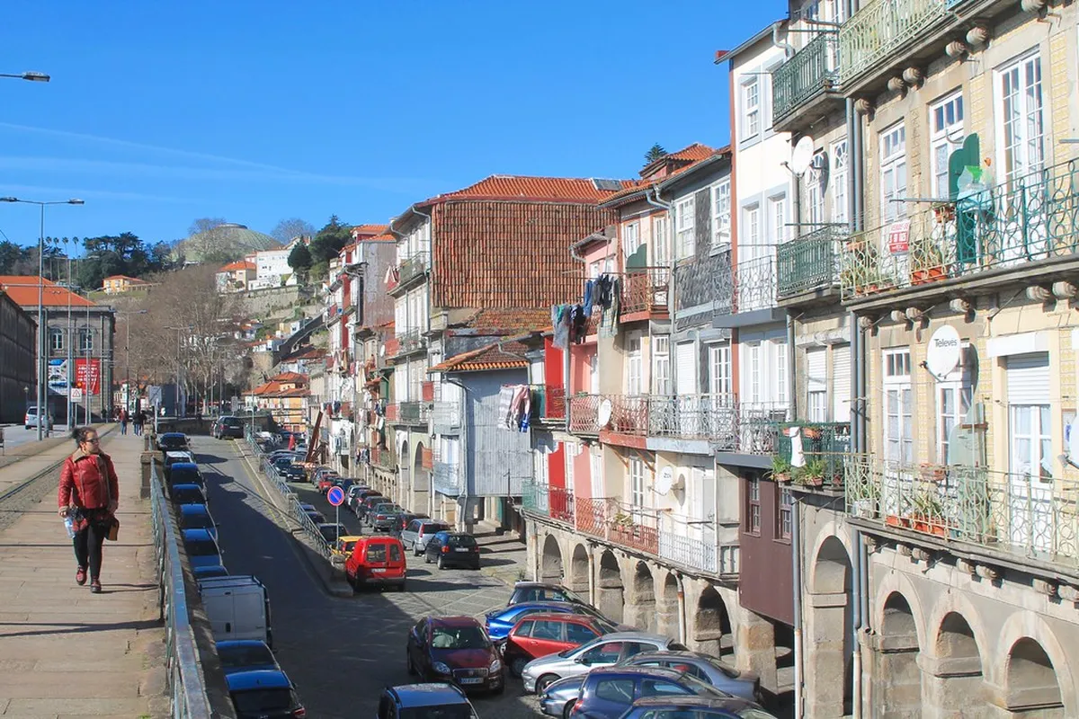 Colourful historic buildings lining the narrow Porto Miragaia waterfront with traditional boats moored below