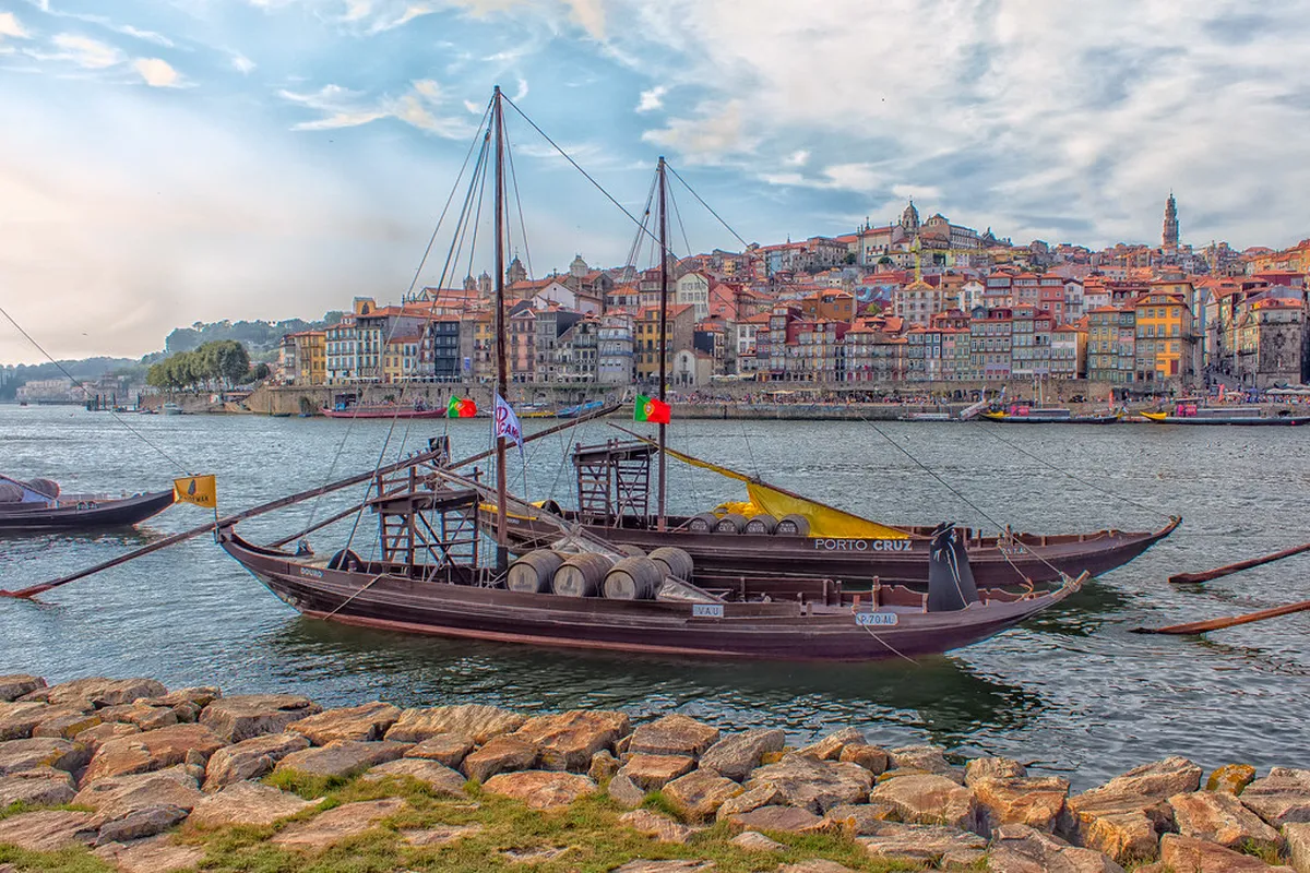 Historic Porto port wine cellars with rows of oak barrels lining the cool stone chambers in Vila Nova de Gaia
