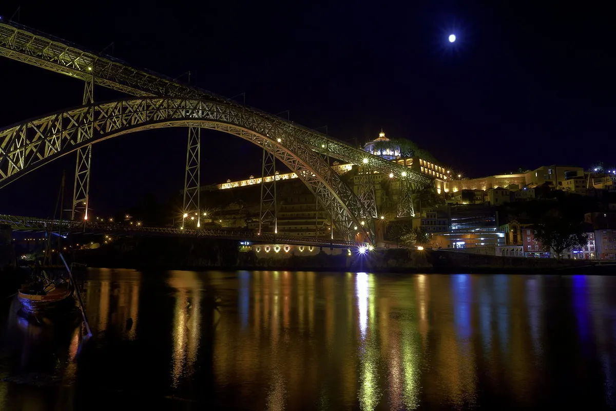 Porto Dom Luís I Bridge illuminated at night with reflections shimmering across the Douro River in the Ribeira district