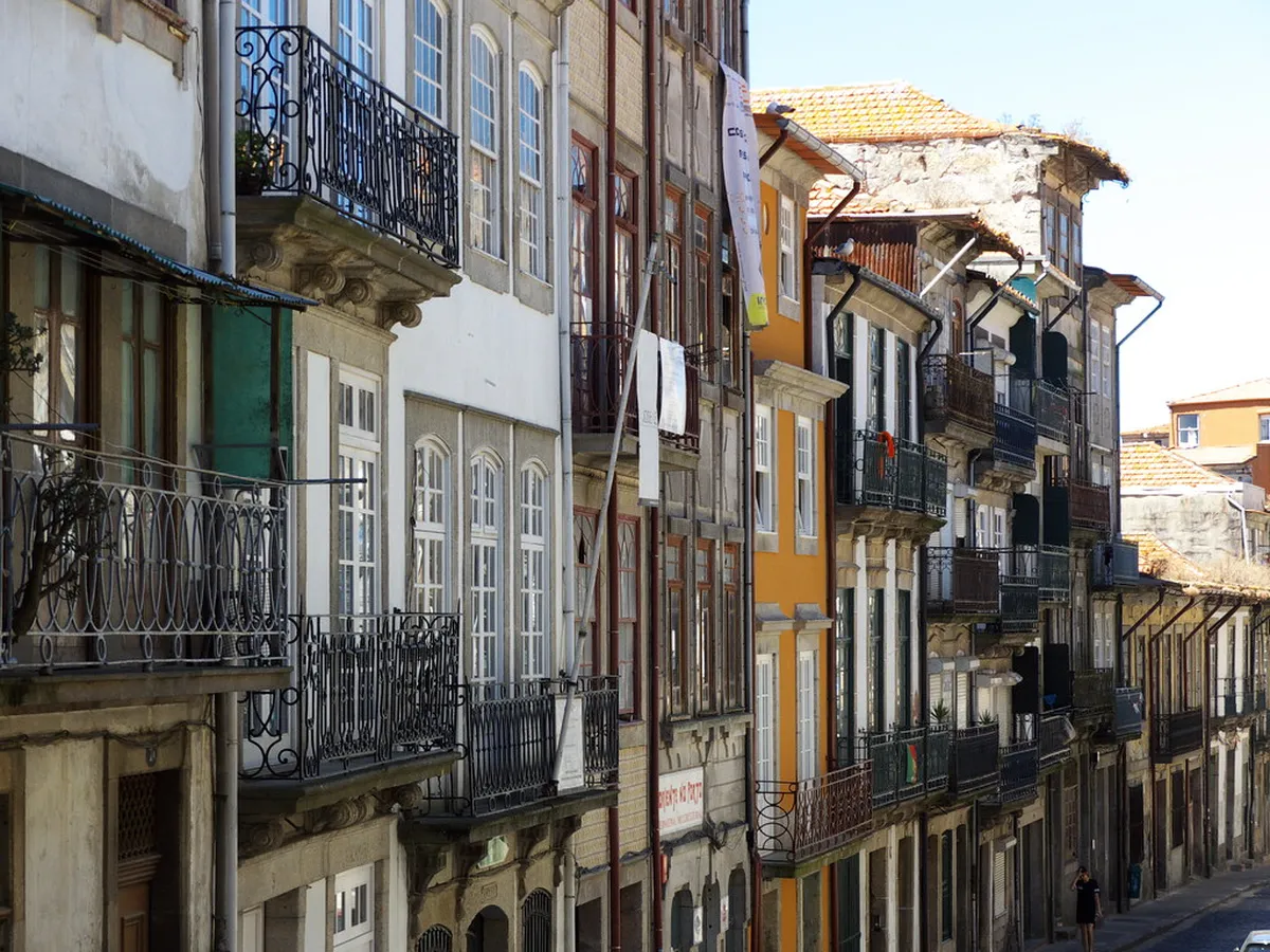 Panoramic rooftop view across Porto old town with terracotta rooftops and the Douro River stretching into the distance