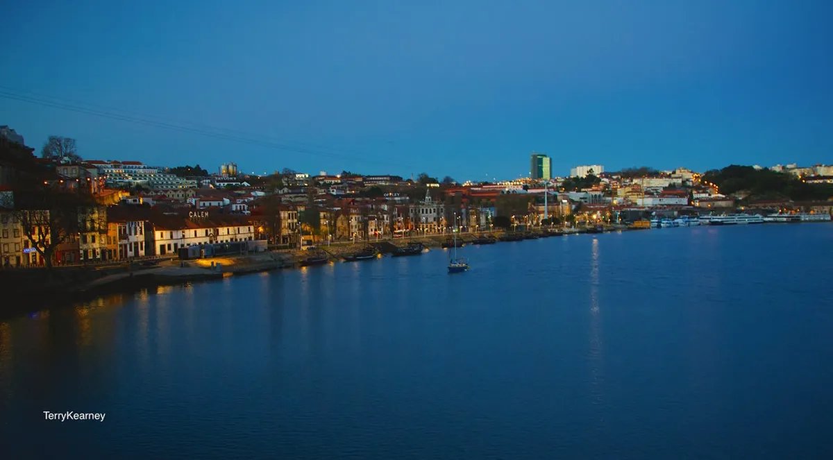 Colorful houses of Porto's Ribeira district reflecting in the Douro River at dusk
