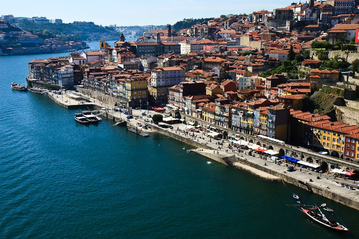 Fresh grilled seafood platter beside Porto's scenic Douro River waterfront with colourful Ribeira buildings in the background
