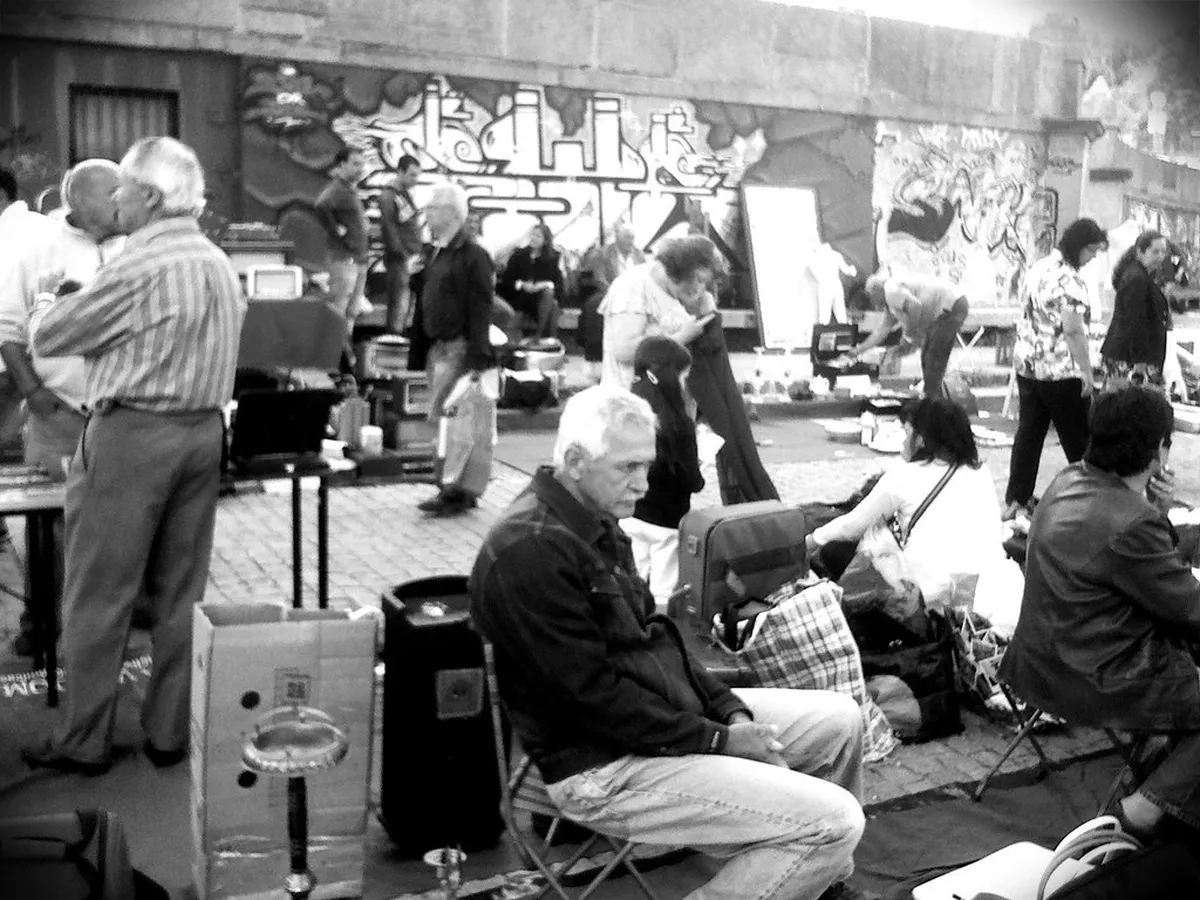 Porto street market with vendors and shoppers browsing antiques and second-hand goods on a Saturday morning