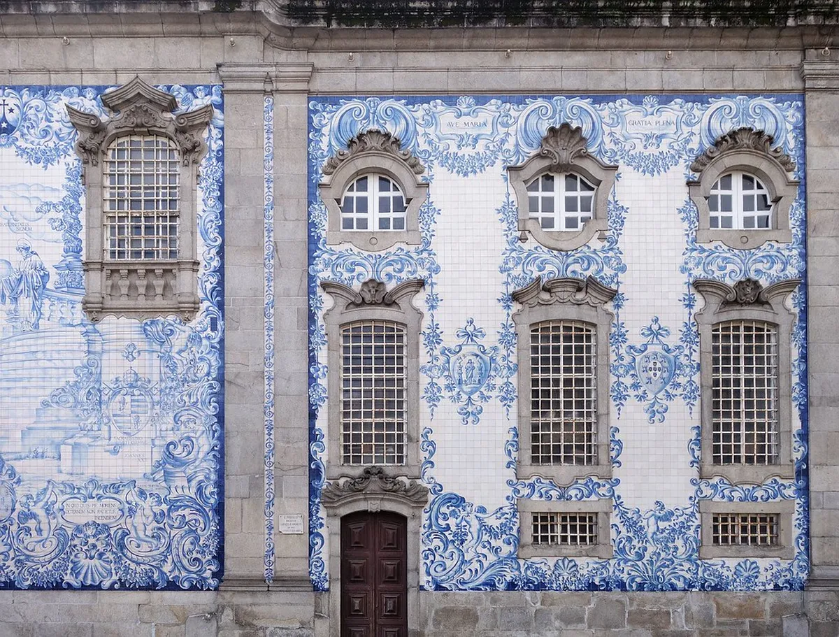 Vibrant blue-and-white azulejo tiled building facade on a narrow Porto street in the historic quarter