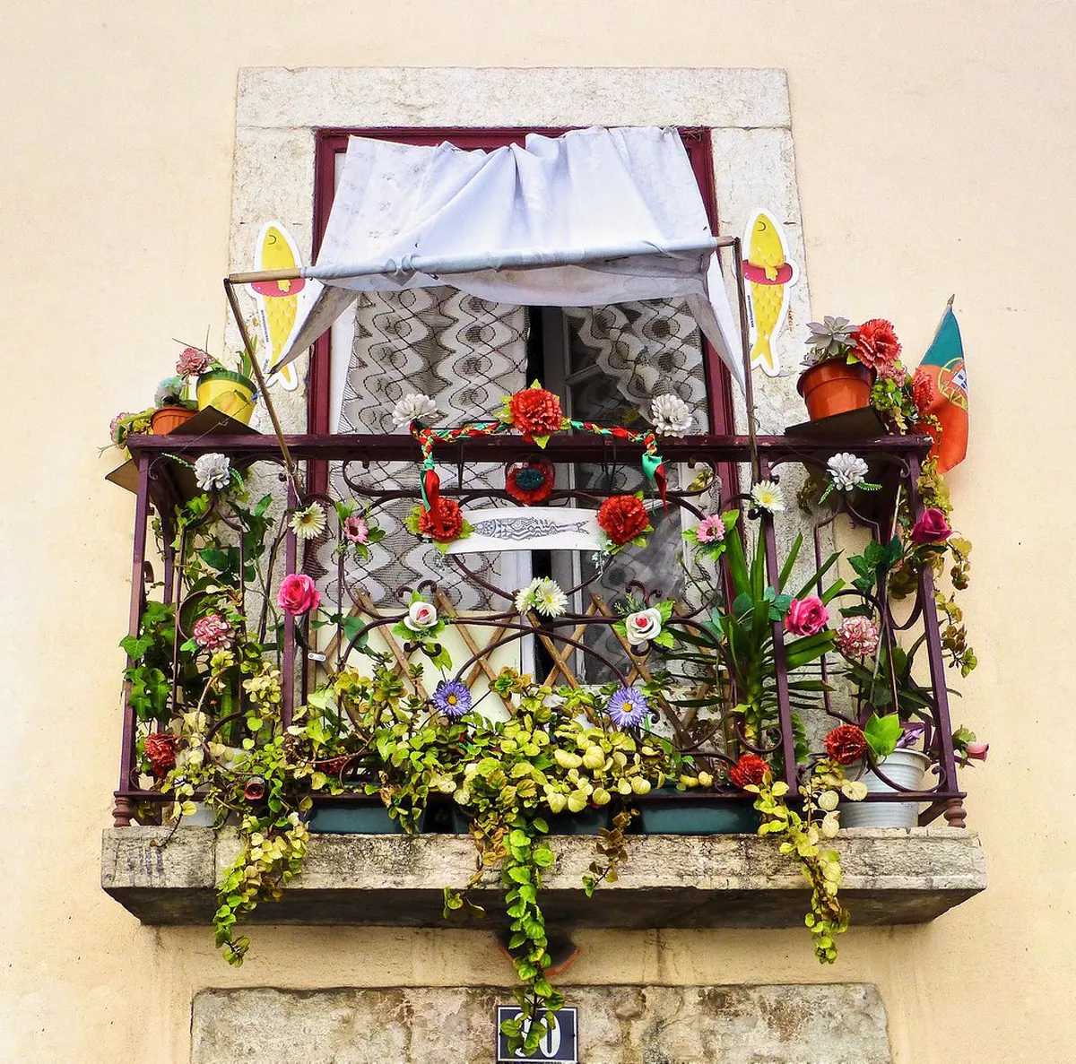 Flower-draped balcony on an Alfama lane